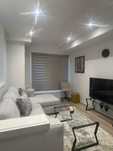 a living room with a couch and a flat screen tv at Modern 3BR FriendlyTown Home in Paris