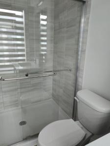a bathroom with a toilet and a glass shower at Modern 3BR FriendlyTown Home in Paris +13 photos
