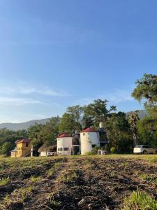 a field with a farm in the background with a car at Rincón San Jerónimo in Tamasopo +16 photos