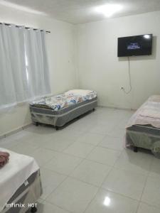 a room with two beds and a flat screen tv at Próximo do carnaval em Olinda in Olinda +12 photos