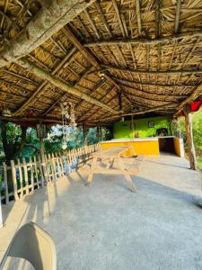 a picnic table and chairs under a wooden roof at Rincón San Jerónimo in Tamasopo
