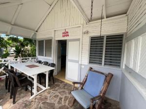 a patio with a table and chairs and a sign at Hostel La Bohème in Las Terrenas