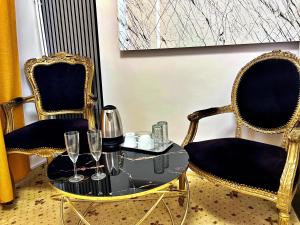 two chairs and a table with wine glasses on it at Hotel Zava Boutique - City Center in Bucharest