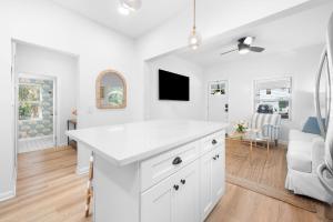 a kitchen with a white counter top and a living room at Casa Madeore Luxury Bungalow in St. Augustine