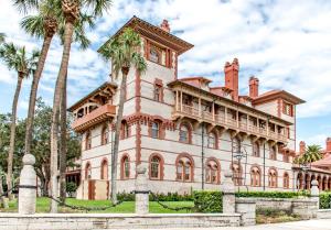 an old house with palm trees in front of it at Casa Madeore Luxury Bungalow in St. Augustine