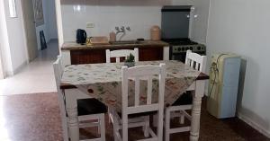 a kitchen with a table with four chairs and a stove at DeptoSarmiento in Paso de los Libres