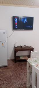 a room with a television on a wall with a table at DeptoSarmiento in Paso de los Libres