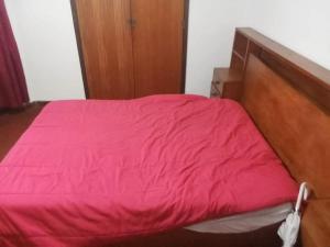 a bed with a red blanket on top of it at apartamento com varios quartos in Coimbra
