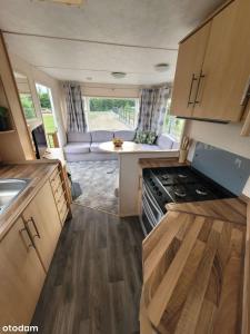 an interior view of a caravan kitchen and living room at Domki nad Szóstakiem in Orzechowo +11 photos