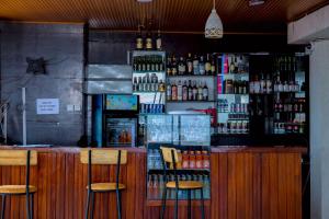 a bar with two stools in front of a counter at Global Village Apartment in Kigali