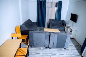 a living room with a couch and a tv at Global Village Apartment in Kigali