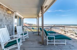 a porch with chairs and the ocean in the background at Jacks - Nags Head MP 12, Oceanfront, Ocean Views, Huge Deck, YMCA Pkg in Nags Head