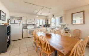 a kitchen with a wooden table and chairs at Jacks - Nags Head MP 12, Oceanfront, Ocean Views, Huge Deck, YMCA Pkg in Nags Head