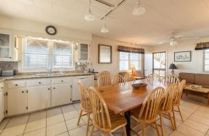 a kitchen and dining room with a wooden table and chairs at Jacks - Nags Head MP 12, Oceanfront, Ocean Views, Huge Deck, YMCA Pkg in Nags Head +68 photos