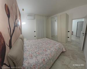 a bedroom with a bed with a floral bedspread at B&B Domus morfeo Caserta in Caserta