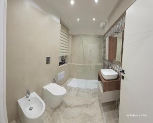 a white bathroom with a sink and a toilet at B&B Domus morfeo Caserta in Caserta