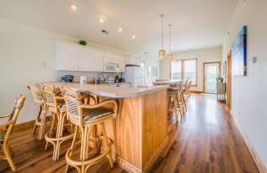 a kitchen with a counter and a bar with chairs at It's A Shore Thing - Nags Head MP 11.5, Ocean View, 130 Yds to Beach, Pool, Hot Tub, Rec Room in Nags Head