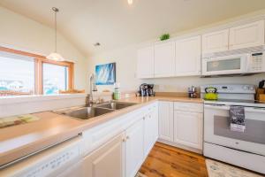 a kitchen with white cabinets and a sink at It's A Shore Thing - Nags Head MP 11.5, Ocean View, 130 Yds to Beach, Pool, Hot Tub, Rec Room in Nags Head