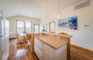a kitchen with a counter and a dining room at It's A Shore Thing - Nags Head MP 11.5, Ocean View, 130 Yds to Beach, Pool, Hot Tub, Rec Room in Nags Head