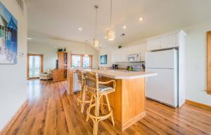 an open kitchen with white appliances and wooden floors at It's A Shore Thing - Nags Head MP 11.5, Ocean View, 130 Yds to Beach, Pool, Hot Tub, Rec Room in Nags Head +49 photos
