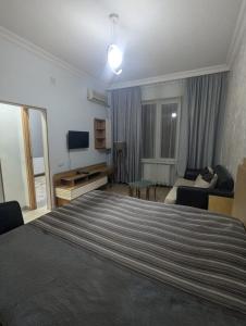 a bedroom with a large bed and a living room at warm house in Tsqaltubo