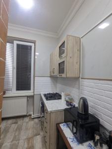 a kitchen with wooden cabinets and a stove at warm house in Tsqaltubo