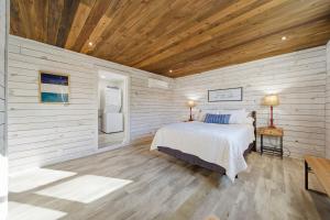 a bedroom with a bed and a refrigerator at Deep Water Stays on Lake Murray in Lake Murray Shores