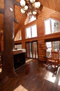 a log cabin with a tree in the center of the room at Le Chalet Bois Rond Relax in Saint-Tite-des-Caps