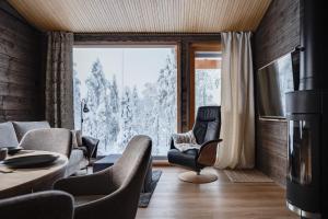 a living room with a couch and chairs and a large window at Villa Light in Ruka