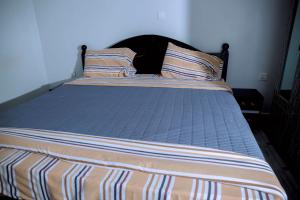 a bed with two pillows on it in a bedroom at Global Village Apartment in Kigali
