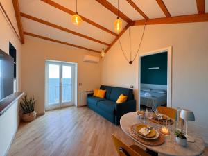 a living room with a blue couch and a table at Marilú vista mare con giardino in Genoa