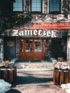 a store front with a wooden door in front at Butikowy Hotel Zameczek in Książ Wielki +80 photos