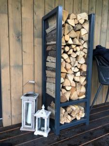 a rack of fire wood next to a pile of logs at Paporoti House in Korostov