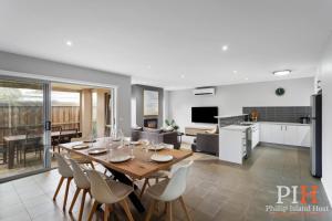 a dining room and living room with a table and chairs at Townhouse with Shared Pool in Cowes in Cowes