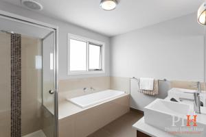 a bathroom with a bath tub and a sink at Townhouse with Shared Pool in Cowes in Cowes