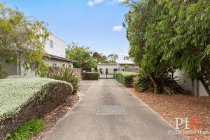 a walkway in front of a house with bushes at Townhouse with Shared Pool in Cowes in Cowes +17 photos