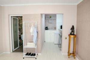 a room with a white kitchen and a room with a mirror at Azur House in Cluj-Napoca