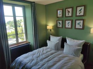 a bedroom with a bed with white pillows and a window at BellevueBretagne - Chambres d'Hôtes in Saint-Jean-du-Doigt
