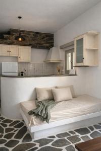 a bed in a room with a kitchen at Lithari Traditional Apartment in Agios Sostis