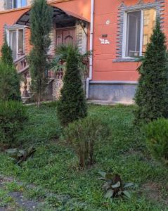 an orange house with trees in front of a yard at warm house in Tsqaltubo