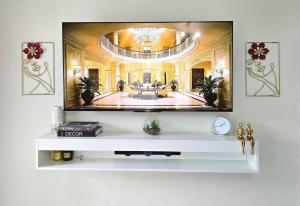 a living room with a tv on a wall at Charming Studio in Golden Triangle in Harare