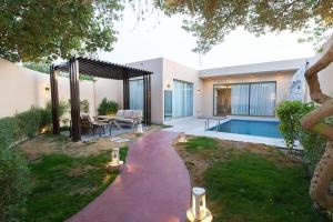 a backyard with a swimming pool and a house at Ramla Resort in Riyadh
