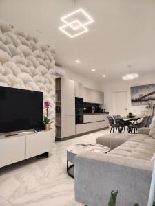 a living room with a couch and a tv at Holiday Home Varese- Family & Group stay with private parking in Varese