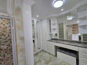 a white bathroom with a sink and a shower at Charming Studio in Golden Triangle in Harare +30 photos