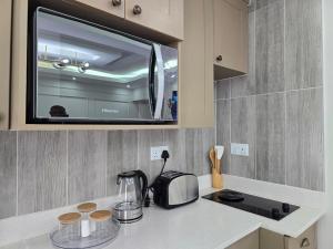 a kitchen with a counter with a toaster and a microwave at Charming Studio in Golden Triangle in Harare
