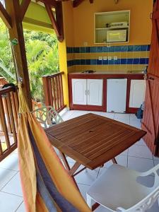 a hammock in a room with a table and a kitchen at Bungalow nature zen in Le Gosier