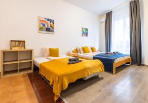 a bedroom with two beds and a couch at Gellerico Apartments Wesselényi Street in Budapest