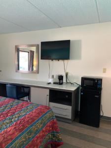 a hotel room with a bed and a desk with a television at Sky Suites in Tybee Island