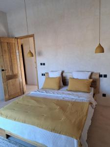 a bedroom with a large bed with yellow pillows at Villa Face a l'océan- Havre de paix & grand confort avec piscine à TOUBAB DIALAW in Rufisque