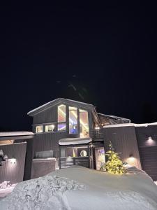 a house in the snow at night at Modern Luxplace with Northern Light view in Tromsø